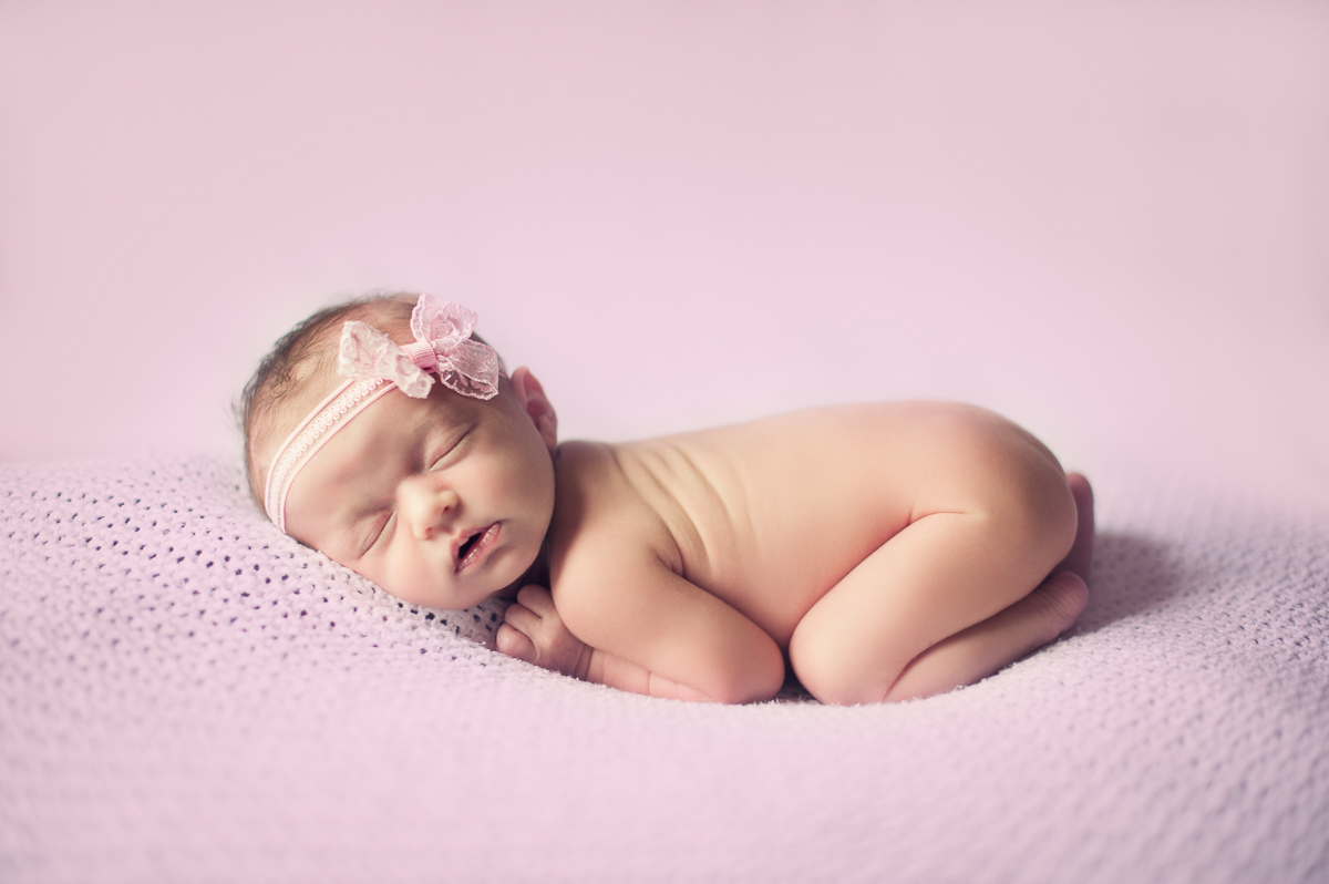Newborn baby girl sleeping during a photo session.