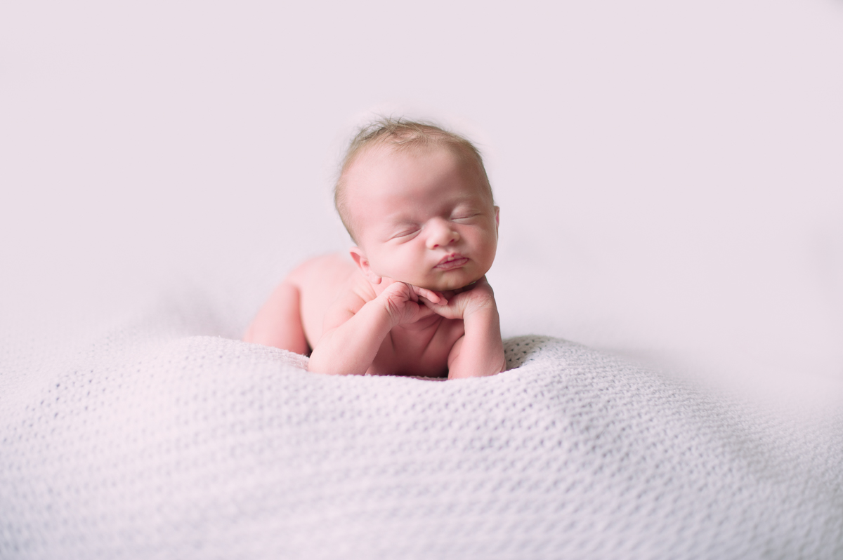 Baby leaning his head on his hands by Greenville SC Newborn Photographer Elizabeth and Charles.