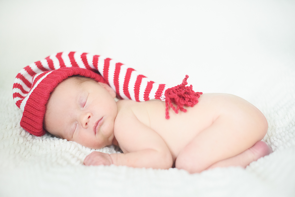 Newborn baby boy wearing a santa hat.