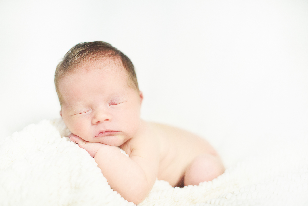 Simple newborn baby sleeping on a white background.